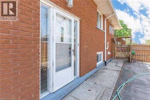 Brick exterior with white storm door and side window - 186 Adeline Avenue, Hamilton, ON - Outdoor With Exterior
