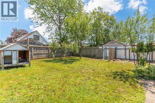 Fenced backyard featuring a grassy lawn, mature trees, and a detached storage shed - 186 Adeline Avenue, Hamilton, ON - Outdoor
