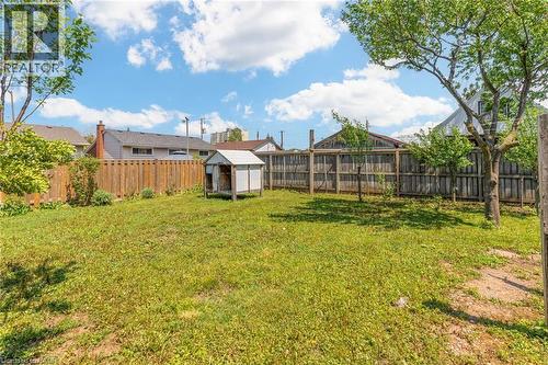Expansive grassy yard area featuring a combination wood privacy fence and mature trees - 186 Adeline Avenue, Hamilton, ON - Outdoor