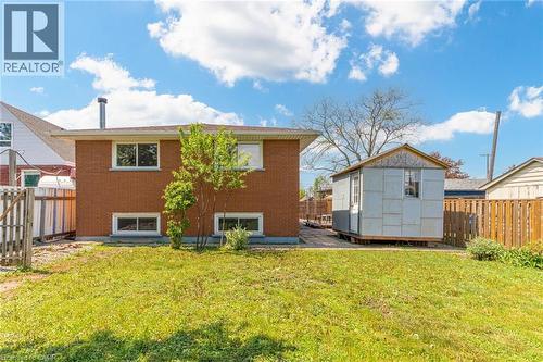 Spacious backyard featuring a grass lawn, wood fencing, and a detached storage shed - 186 Adeline Avenue, Hamilton, ON - Outdoor