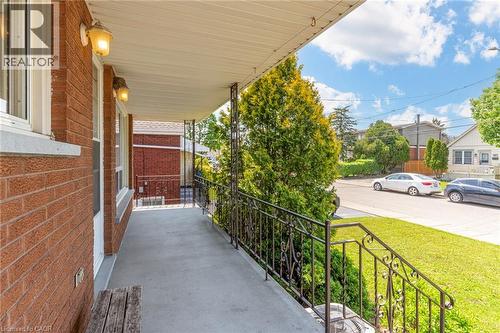 Covered porch featuring a concrete surface and decorative wrought iron railing - 186 Adeline Avenue, Hamilton, ON - Outdoor With Exterior