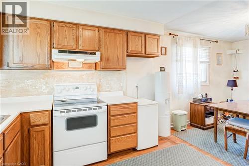 Kitchen featuring wood cabinetry, white countertops, a white electric range, and wood-finish flooring - 186 Adeline Avenue, Hamilton, ON - Indoor Photo Showing Kitchen