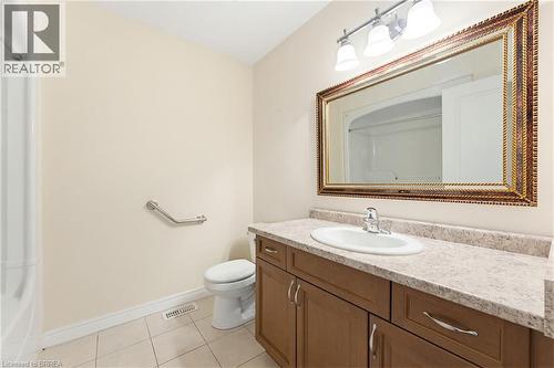 Bathroom featuring a vanity with a light-toned countertop, an undermount sink, and a framed mirror with overhead lighting - 6 General Street, Brantford, ON - Indoor Photo Showing Bathroom