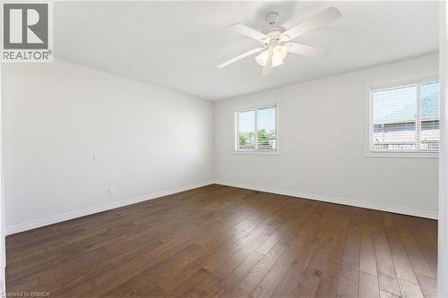 Bright room featuring wood-finish flooring, white walls, and a ceiling fan with integrated lighting - 6 General Street, Brantford, ON - Indoor Photo Showing Other Room