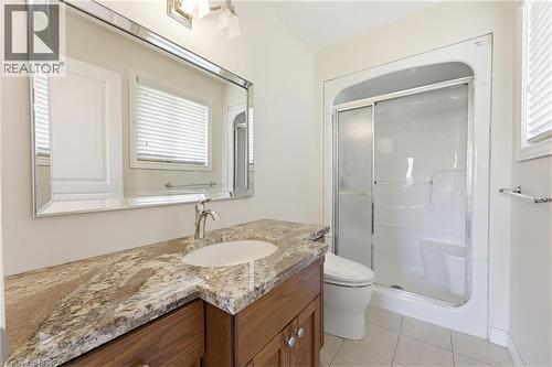 Bathroom featuring a vanity with a light-colored, patterned countertop, an undermount sink, and a framed mirror - 6 General Street, Brantford, ON - Indoor Photo Showing Bathroom
