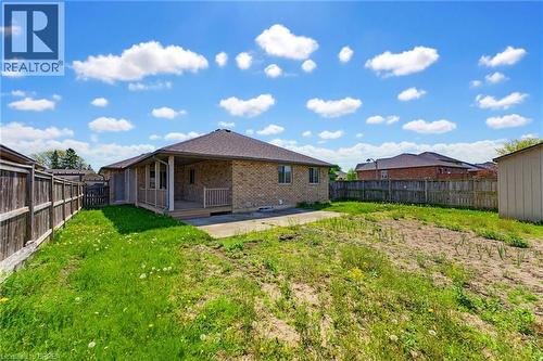 Expansive backyard featuring a partial grass lawn, a covered patio with wood deck and railing, and a privacy fence - 6 General Street, Brantford, ON - Outdoor With Backyard