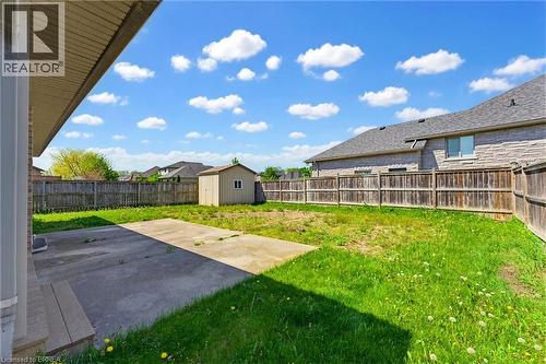 Expansive backyard featuring a concrete patio, wooden privacy fencing, and a detached storage shed - 6 General Street, Brantford, ON - Outdoor