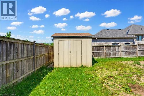 Enclosed backyard featuring a wooden storage shed with an asphalt shingle roof - 6 General Street, Brantford, ON - Outdoor