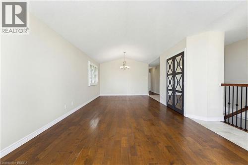 Spacious living area featuring rich wood-finish flooring, vaulted ceilings, and a decorative chandelier - 6 General Street, Brantford, ON - Indoor Photo Showing Other Room