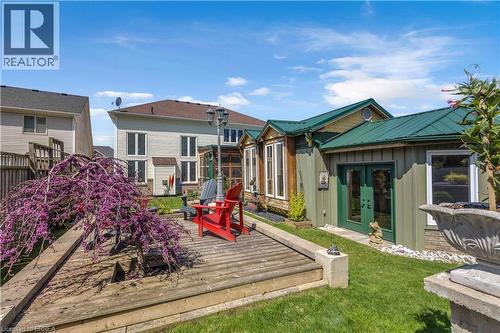Backyard features a multi-level wooden deck, mature flowering tree, and manicured lawn - 69 Hunter Way, Brantford, ON - Outdoor