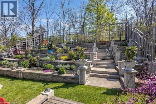 Multi-tiered terraced garden featuring stone retaining walls and mature plantings - 69 Hunter Way, Brantford, ON - Outdoor