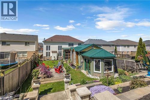 Expansive backyard featuring a green-roofed garden structure, a wooden deck, manicured lawn, and tiered landscaping - 69 Hunter Way, Brantford, ON - Outdoor
