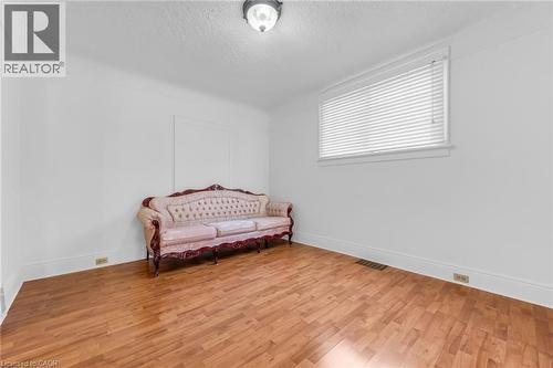 Room featuring wood-finish flooring, white walls, and a recessed window with blinds - 168 Britannia Avenue, Hamilton, ON - Indoor Photo Showing Bedroom