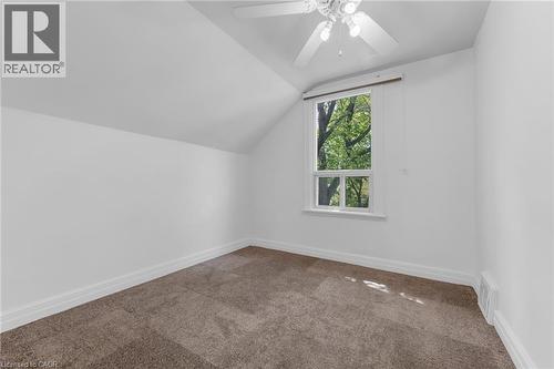 Attic room featuring a single window with white trim, sloped ceiling, light-colored walls, and brown carpeting - 168 Britannia Avenue, Hamilton, ON - Indoor Photo Showing Other Room