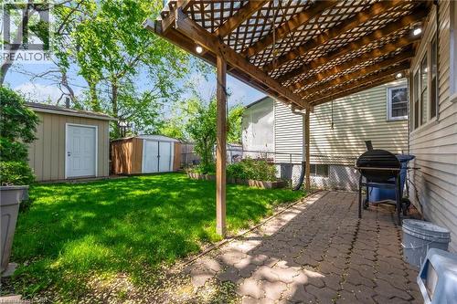 Covered patio with paver stones, featuring a wood lattice pergola and integrated lighting - 168 Britannia Avenue, Hamilton, ON - Outdoor With Exterior