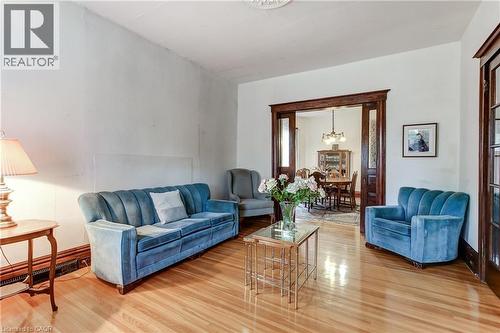 Hardwood flooring throughout the room, featuring white walls and dark wood trim - 18 Fairleigh Crescent, Hamilton, ON - Indoor Photo Showing Living Room