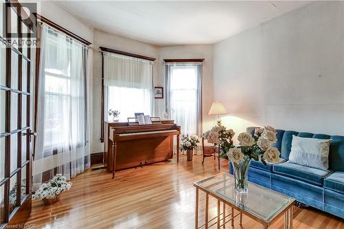 Bright interior with rich wood-finish flooring, multiple windows, and a French door featuring glass panels - 18 Fairleigh Crescent, Hamilton, ON - Indoor
