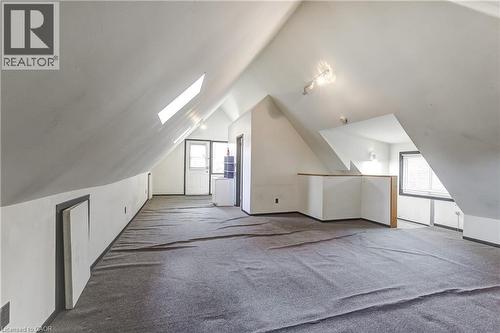 Spacious attic conversion featuring sloped ceilings, two skylights, track lighting, and gray carpeting - 18 Fairleigh Crescent, Hamilton, ON - Indoor Photo Showing Other Room
