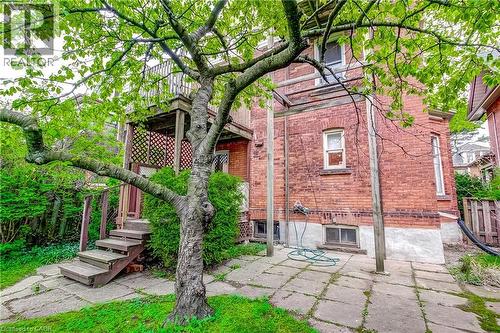 Brick exterior featuring a multi-level deck with wood stairs and lattice screening - 18 Fairleigh Crescent, Hamilton, ON - Outdoor