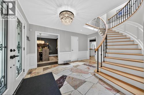 Grand entryway featuring a curved staircase with natural wood treads and black iron balusters - 25 Braemar Place, Hamilton, ON - Indoor Photo Showing Other Room