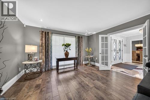 Spacious living area featuring wood-finish flooring, crown molding, and recessed lighting - 25 Braemar Place, Hamilton, ON - Indoor