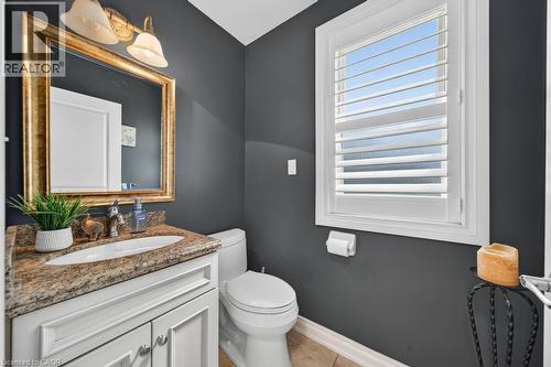 Bathroom featuring a white vanity with paneling, a stone countertop, and an undermount sink - 25 Braemar Place, Hamilton, ON - Indoor Photo Showing Bathroom