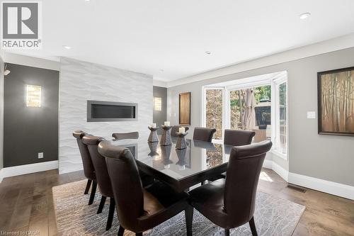 Recessed linear GAS fireplace set within a textured accent wall - 25 Braemar Place, Hamilton, ON - Indoor Photo Showing Dining Room With Fireplace