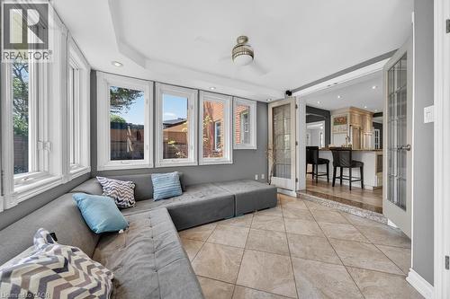 Sunroom featuring a bank of windows, tiled flooring, recessed lighting, and French doors opening to a kitchen space with an island - 25 Braemar Place, Hamilton, ON - Indoor
