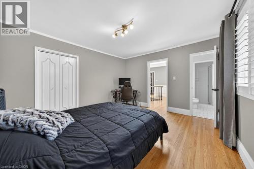 Hardwood-style flooring throughout this room with light gray painted walls - 25 Braemar Place, Hamilton, ON - Indoor Photo Showing Bedroom