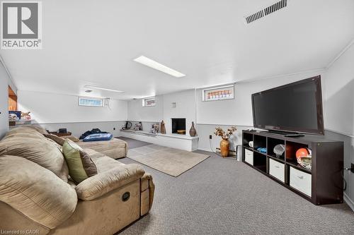 Finished basement space featuring recessed lighting, a built-in bench, carpet flooring, and white walls with a gray wainscoting detail - 25 Braemar Place, Hamilton, ON - Indoor