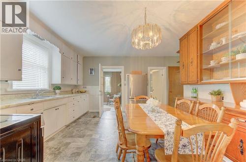 Bright kitchen and dining area featuring a window-side sink, white cabinetry, and a patterned flooring - 1463 Kossuth Road, Cambridge, ON - Indoor Photo Showing Other Room