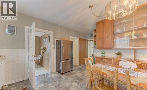 Kitchen dining area featuring wood-finish cabinetry, a built-in display hutch, and a chandelier light fixture - 1463 Kossuth Road, Cambridge, ON - Indoor Photo Showing Dining Room