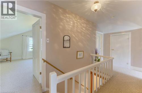 Upper-level hallway featuring neutral wall paint, light-toned carpet flooring, a white spindle railing, and a semi-flush mount ceiling light - 1463 Kossuth Road, Cambridge, ON - Indoor Photo Showing Other Room