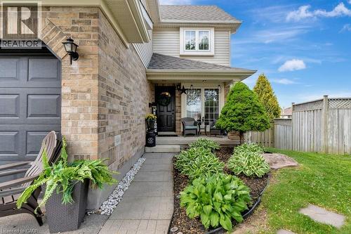 Exterior facade featuring a brick and siding construction, covered front entrance, established landscaping, a concrete pathway, and a privacy fence - 49 Small Court, Cambridge, ON - Outdoor With Deck Patio Veranda