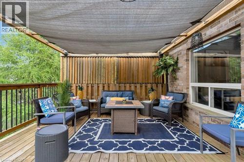 Elevated wood-finish deck featuring a sunshade canopy, brick exterior wall, and a privacy fence - 49 Small Court, Cambridge, ON - Outdoor With Deck Patio Veranda With Exterior