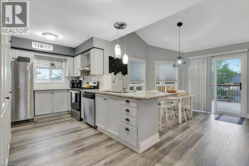 Kitchen featuring white cabinetry, wood-finish flooring, stainless steel appliances, and a central island with a granite-style countertop - 49 Small Court, Cambridge, ON - Indoor Photo Showing Kitchen With Upgraded Kitchen