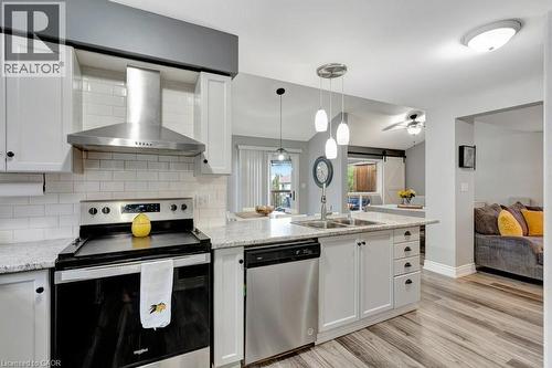 Modern kitchen featuring white shaker cabinetry, stainless steel appliances, subway tile backsplash, and light-toned countertop - 49 Small Court, Cambridge, ON - Indoor Photo Showing Kitchen With Double Sink With Upgraded Kitchen