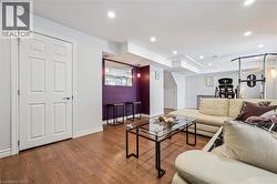 Recessed lighting illuminates this versatile space featuring wood-finish flooring - 