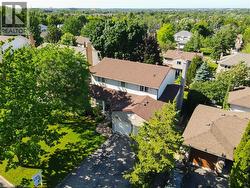 Residential property featuring a two-story structure with a brown shingle roof, attached garage, and a paved driveway - 