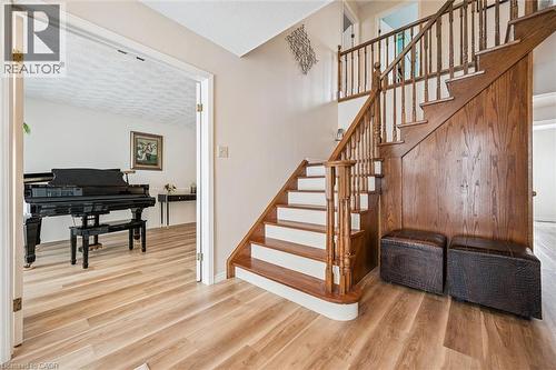 Foyer featuring a wood-finish staircase with white risers, light wood-finish flooring, and a wide entryway opening to an additional room - 488 Heather Hill Place, Waterloo, ON - Indoor Photo Showing Other Room