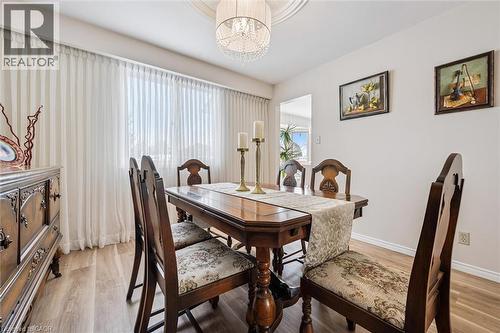 Dining area featuring wood-finish flooring, a decorative ceiling medallion, and a crystal chandelier - 488 Heather Hill Place, Waterloo, ON - Indoor Photo Showing Dining Room