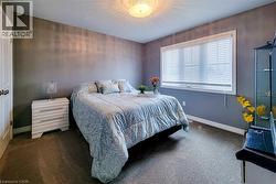 Carpeted room featuring a ceiling-mounted light fixture, a window with horizontal blinds, and baseboard trim - 