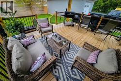 Spacious wood-plank deck featuring black metal railings and direct access to a grassy yard - 