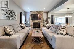 Living area featuring a floor-to-ceiling stone fireplace, recessed lighting, and wood-finish flooring - 