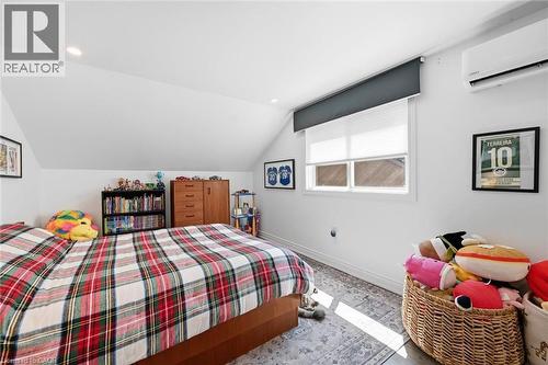 Attic room featuring a sloped ceiling, recessed lighting, and a wall-mounted mini-split system - 24 Glenwood Crescent, Hamilton, ON - Indoor Photo Showing Bedroom