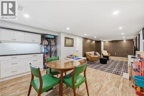 Spacious finished lower level featuring recessed lighting, wood-finish flooring, and a stone-look accent wall - 24 Glenwood Crescent, Hamilton, ON - Indoor