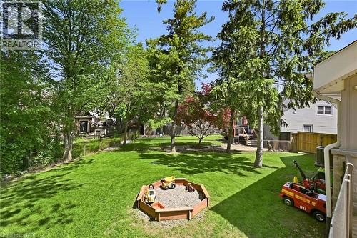 Expansive backyard featuring a manicured lawn, mature trees, and a wooden sandbox - 24 Glenwood Crescent, Hamilton, ON - Outdoor