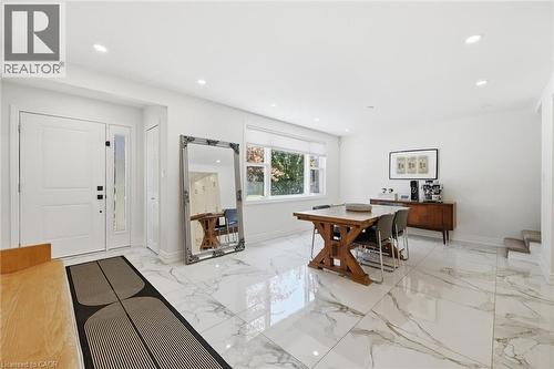 Bright open-concept space featuring large format marble-look flooring, recessed lighting, and a front entry door with a frosted sidelight - 24 Glenwood Crescent, Hamilton, ON - Indoor