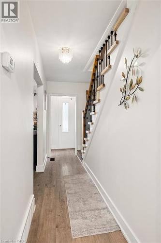 Entry hallway with wood-finish flooring, white baseboards, and a contemporary flush-mount ceiling fixture - 786 S Stirling Avenue S, Kitchener, ON - Indoor Photo Showing Other Room