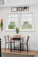 Recessed ceiling lighting illuminates a white wall with two windows featuring white trim - 